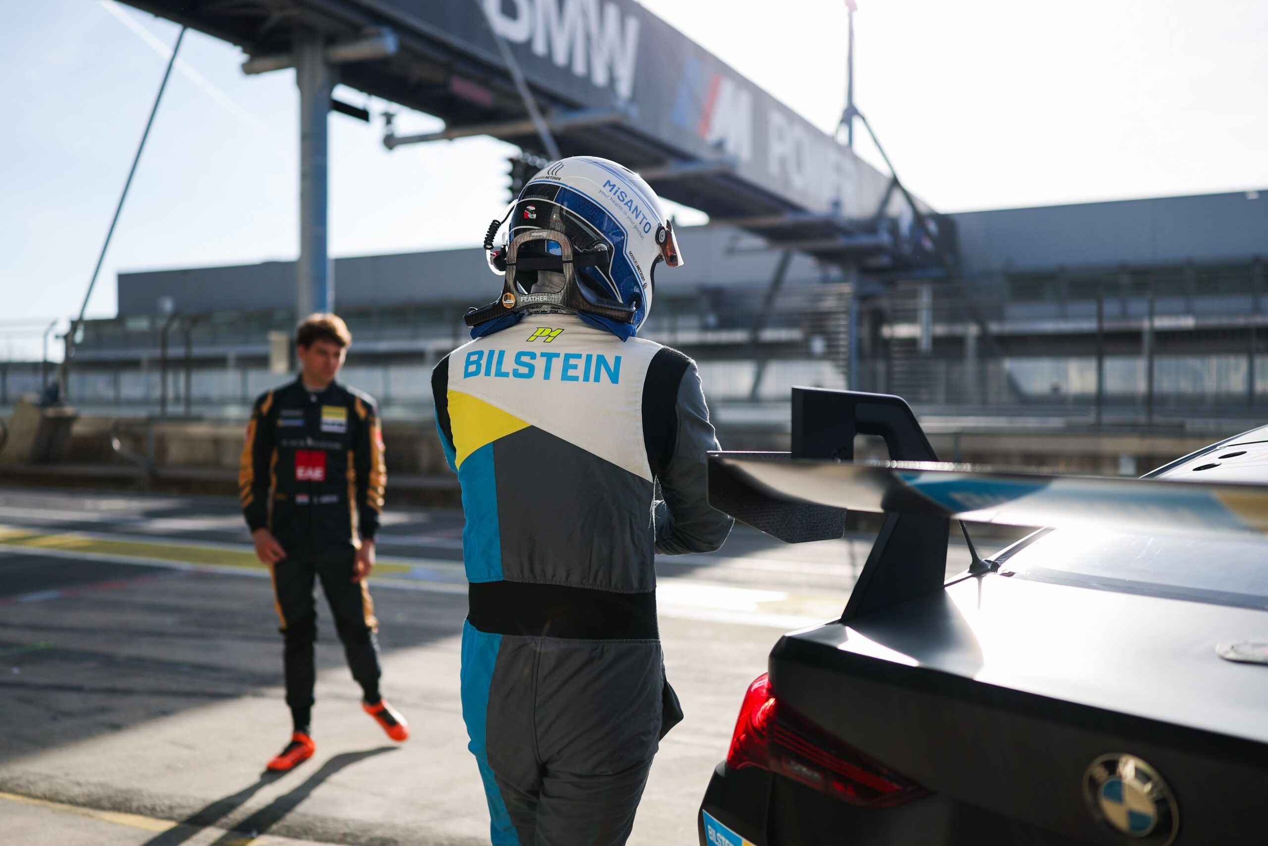 BILSTEIN Racing Team driver with helmet and racing suit on the way to the racing car